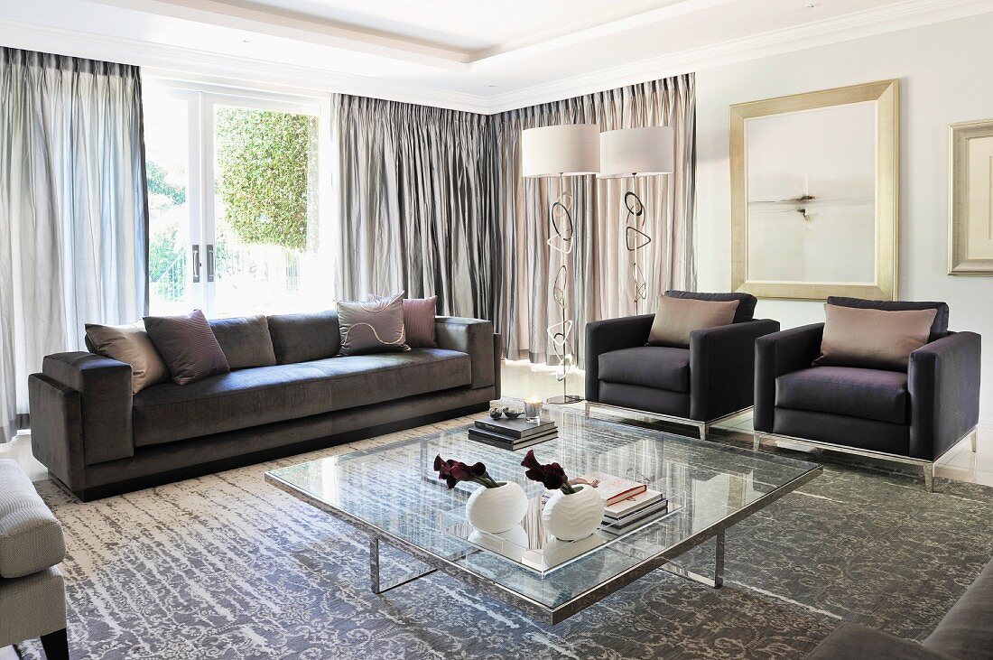 Large, elegant living room with sofa set and glass coffee table in foreground