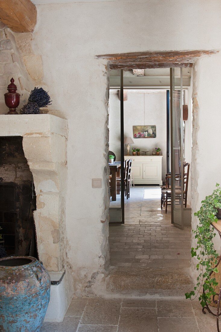 Blick neben gemauertem Kamin und blaue Bodenvase in provenzalische Küche