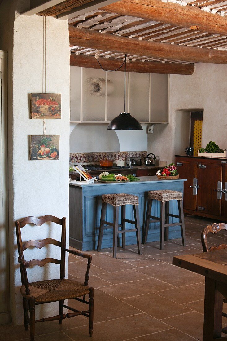 Kleine, blau getönte Frühstückstheke in der rustikalen Küche eines provenzalischen Landhauses