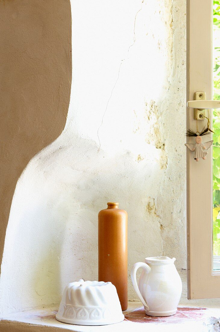 Stillleben mit Kuchenform, Tonflasche und Krug in einer gebogenen Fensternische