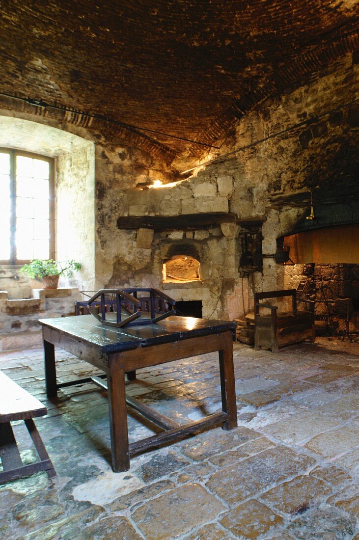 Rustic kitchen within the sandstone walls of historical Chateau de Cassaigne