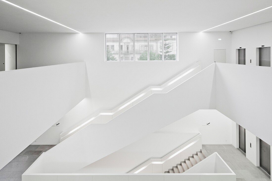 Flights of white stairs in spacious stairwell of modern building