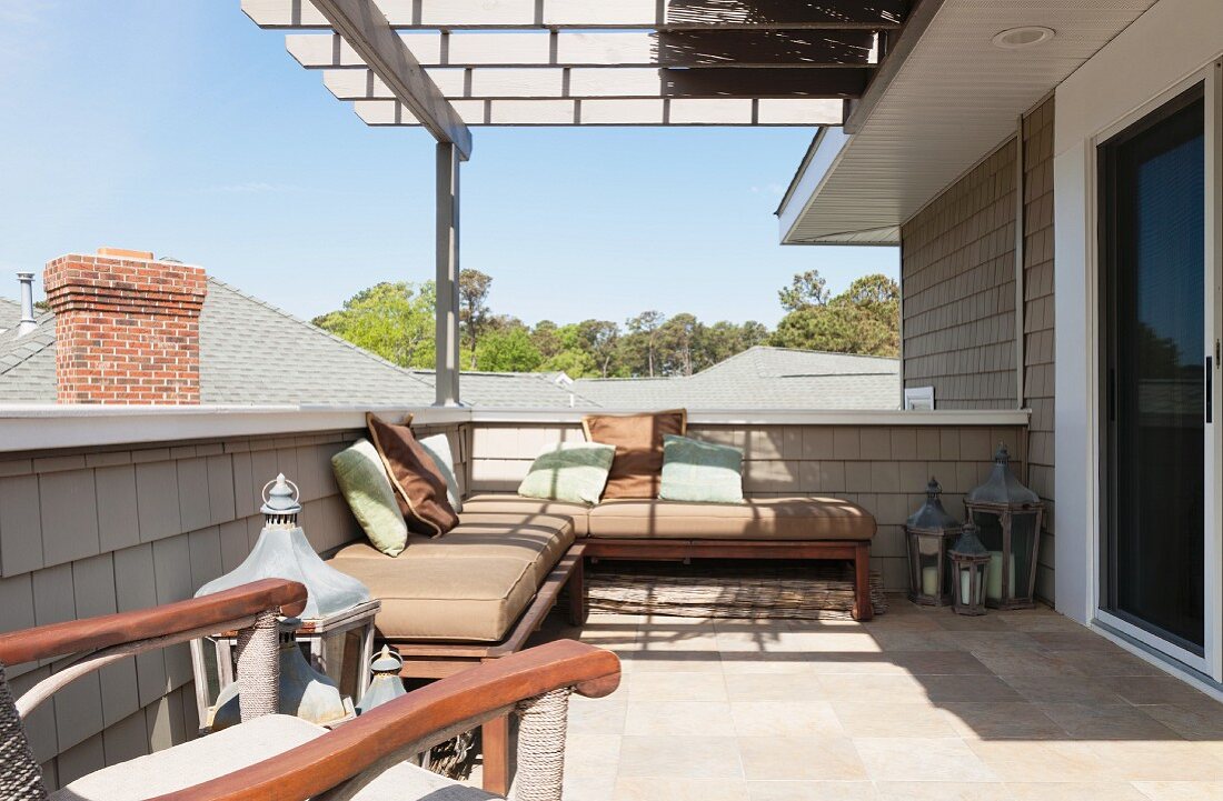 Überdachte Dachterrasse mit gemütlichen Sitzmöbeln