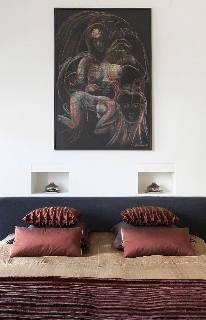 Elegantes Doppelbett mit Kissen und Decke in Brauntönen, Nachttischlampen in Wandnischen und Bild an der Wand