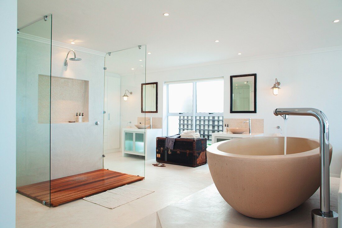 Spacious, minimalist bathroom; central glazed shower cabinet with wooden slatted floor and large shower head
