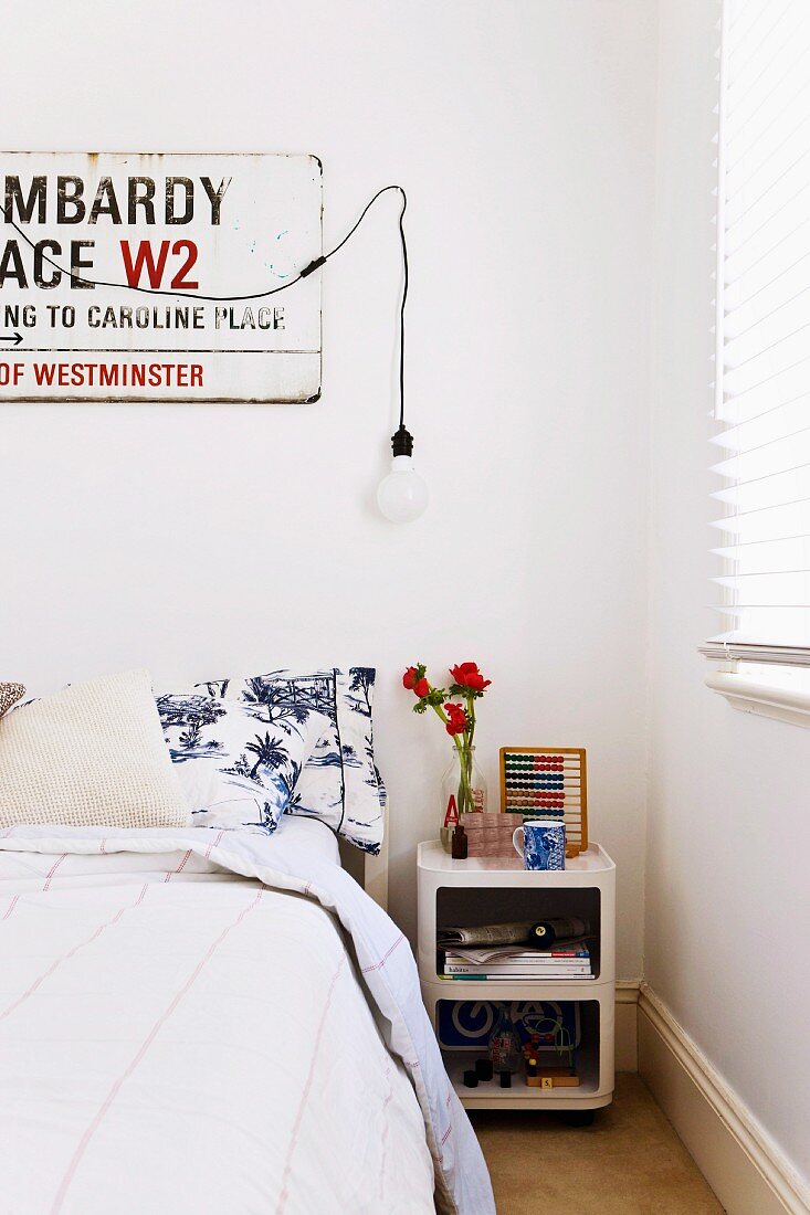 Bedroom with street sign on wall and retro bedside cabinet