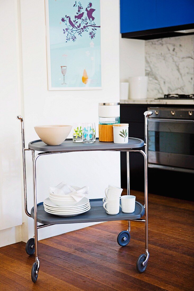 Trolley with dishes in modern kitchen