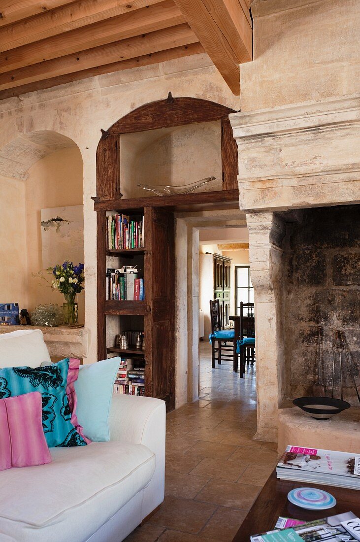 Sitzplatz vor offenem Kamin und Durchblick in das angrenzende Esszimmer eines alten, provenzalischen Wohnhauses