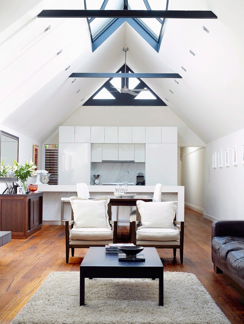 Open-plan interior with lounge, dining area, kitchen & various window elements in gable ceiling