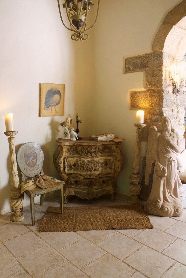 Barocke Kommode und Stuhl neben Kerzenständer auf Boden in Zimmerecke eines mediterranen Landhauses