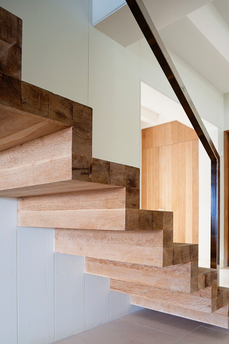 Luxurious, solid wood staircase with metal bannister in modern interior