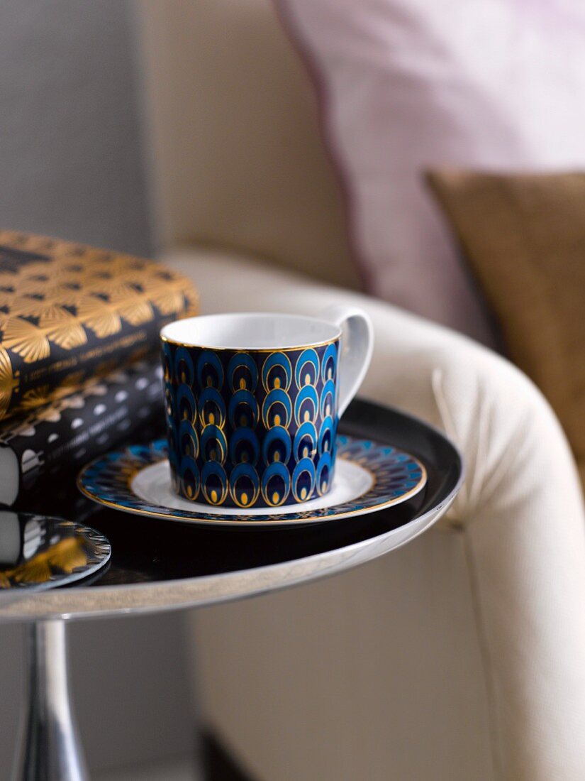 Cup and saucer and books on side table in living room