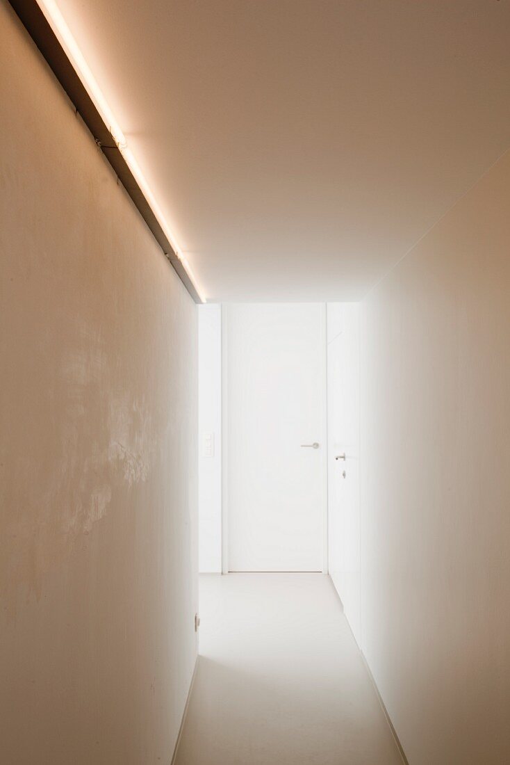 Minimalistischer Gang mit indirektem Licht an Wand