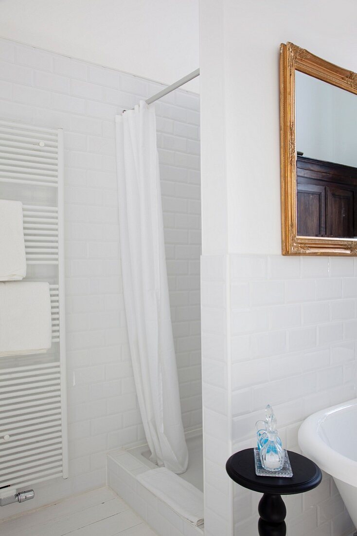 Duschkabine mit Vorhang in einem weißen Badezimmer