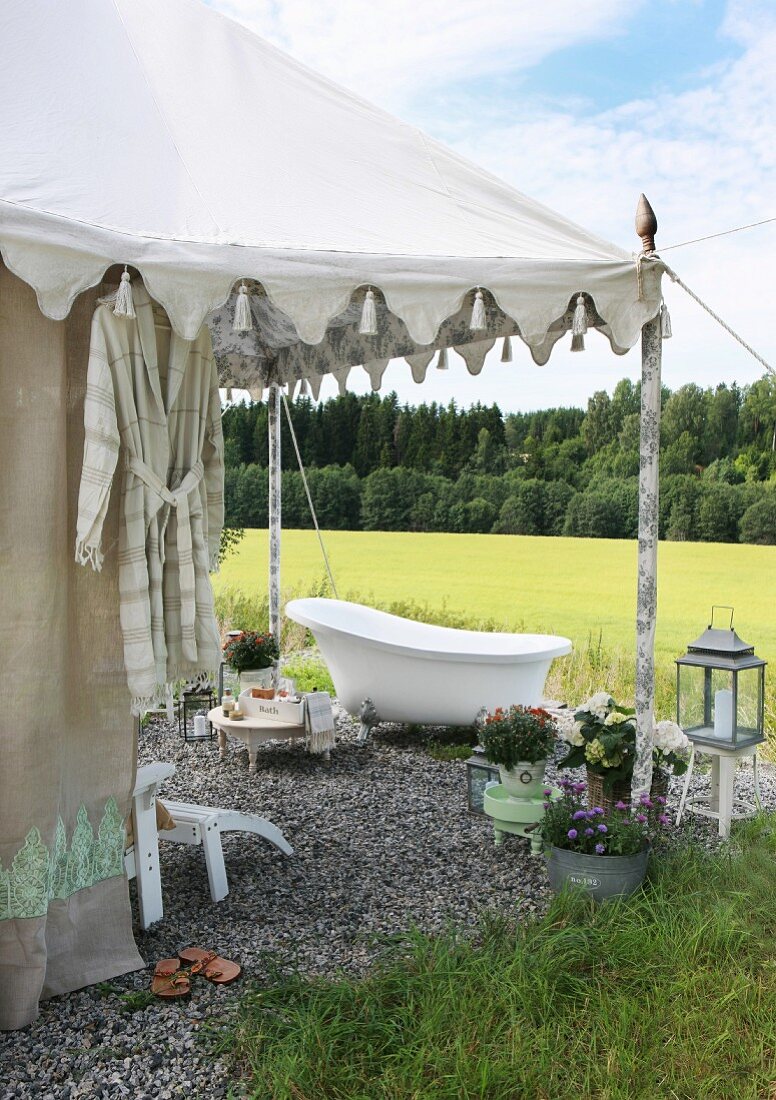 Badewanne auf Kiesboden vor Zelt in orientalischem Stil und Blick in die Landschaft