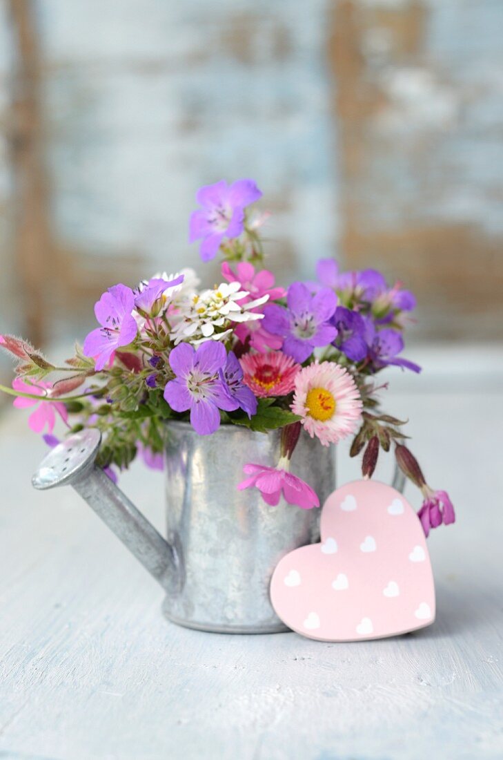 Blumenstrauss aus dem Garten in Blech Giesskanne und rosa Dekoherz