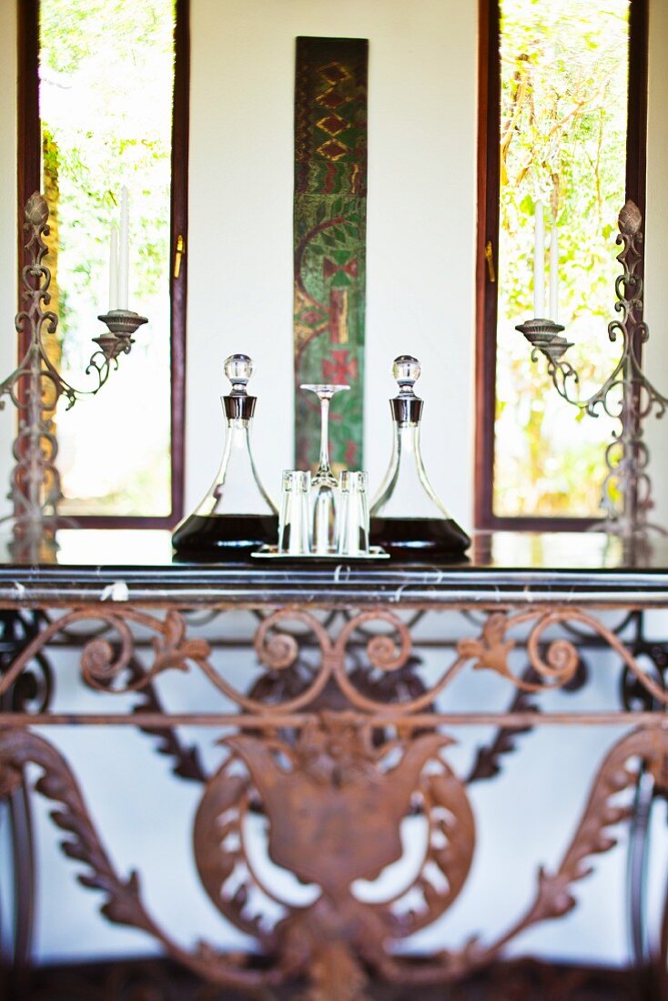 Wandtisch aus rostigem Schmiedeeisen mit eleganten Kristallkaraffen