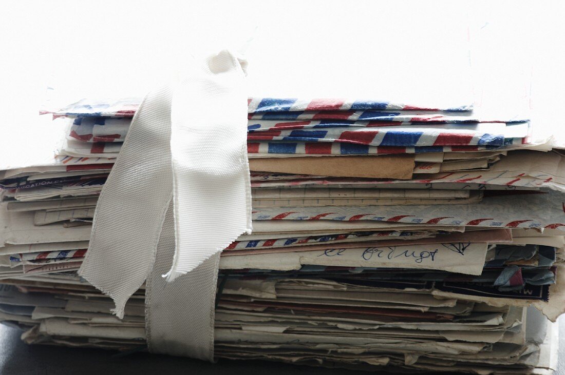 Stapel handschriftlicher Briefe per Luftpost, mit weißem Geschenkband zusammengehalten