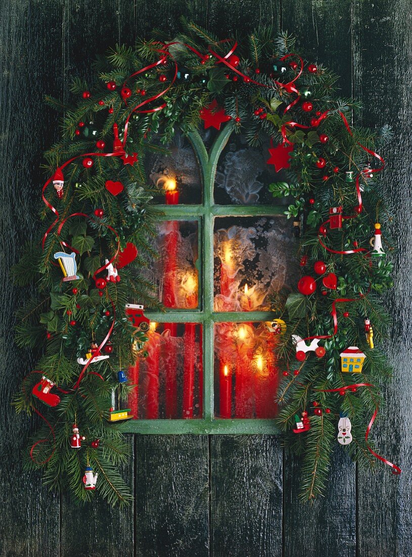 Weihnachtsfenster mit Kerzen und einer Weihnachtsgirlande