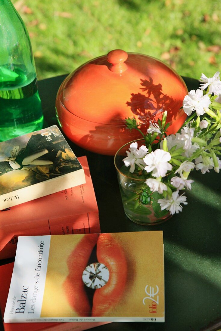 Books, flowers and pot on garden table