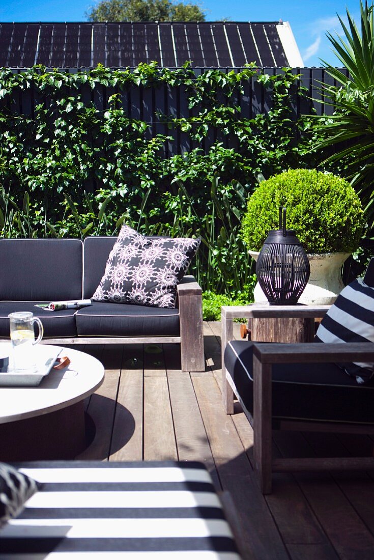 Comfortable garden furniture on wooden terrace in urban surroundings