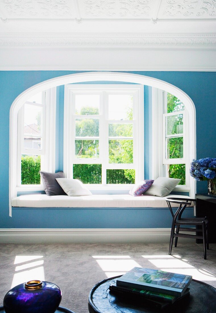 Blaues Jugendstil Wohnzimmer mit Sitzbank in Fensternische und Gartenblick