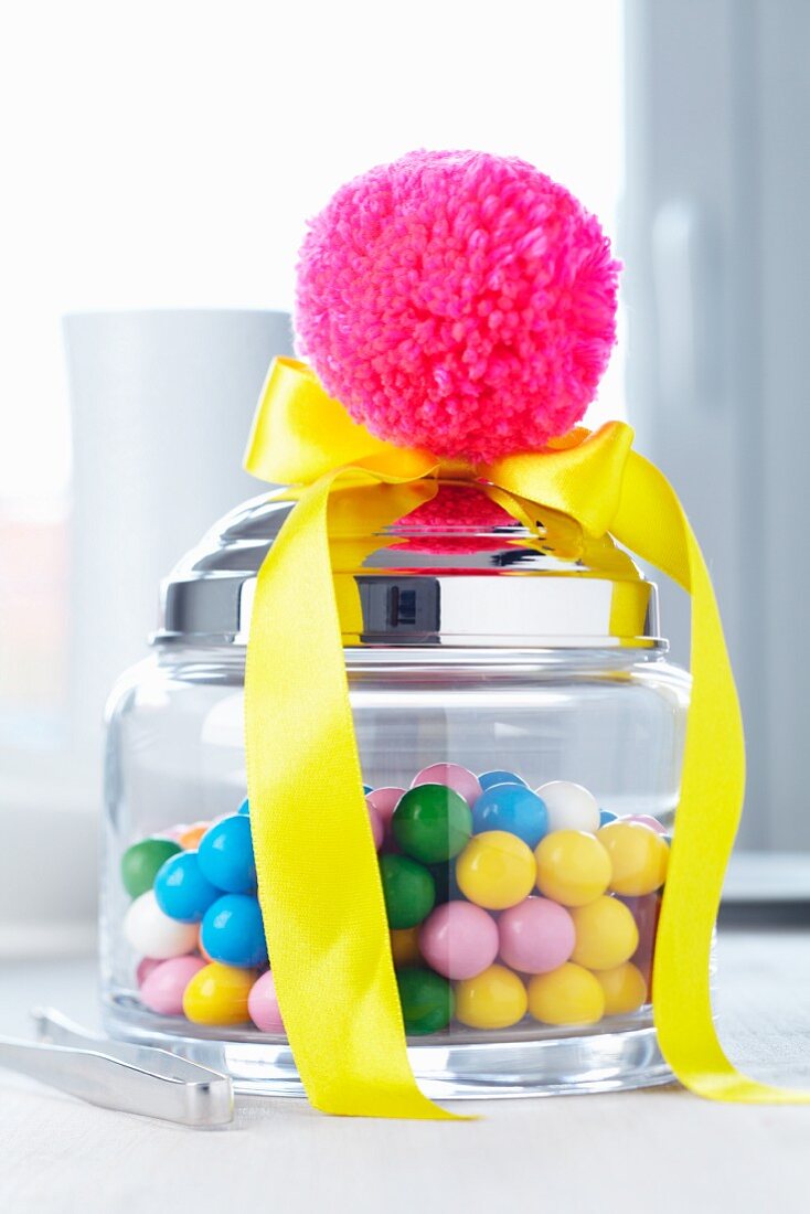 Jar of sweets decorated with yellow satin ribbon & pink pompom