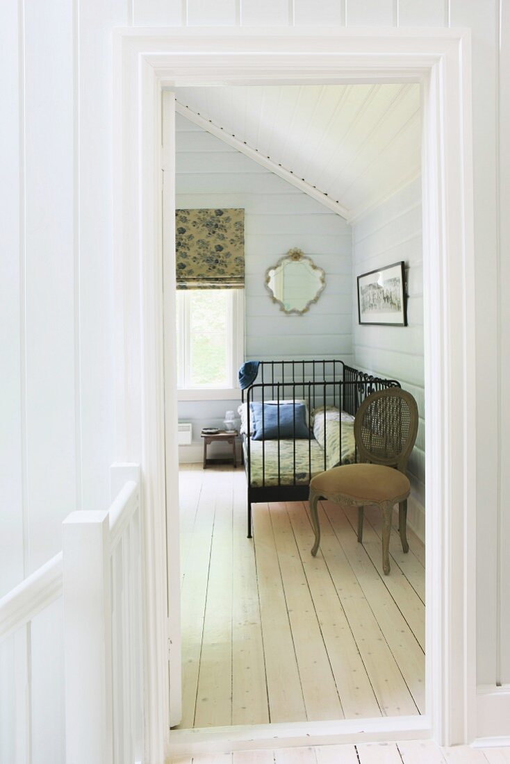 Attic bedroom with white wood panelling