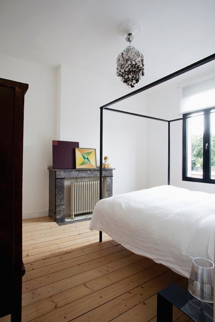 Bett mit modernem Baldachin in modernisiertem Altbau Schlafzimmer mit hellem Dielenboden