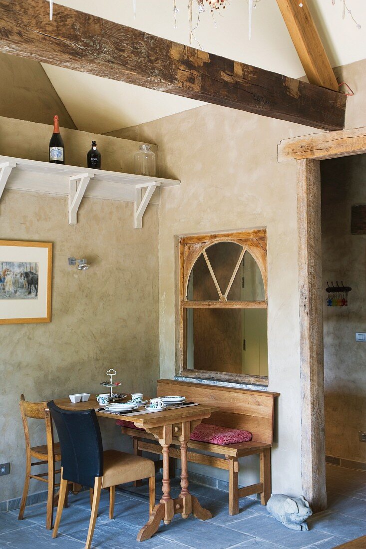 Set breakfast table in corner of dining room below rustic exposed roof structure