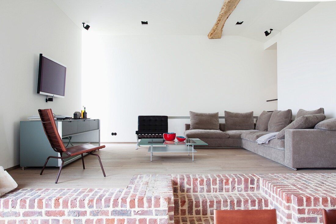 Blick auf Empore mit gemütlicher Couchecke und Sideboard in minimalistischem Loungebereich