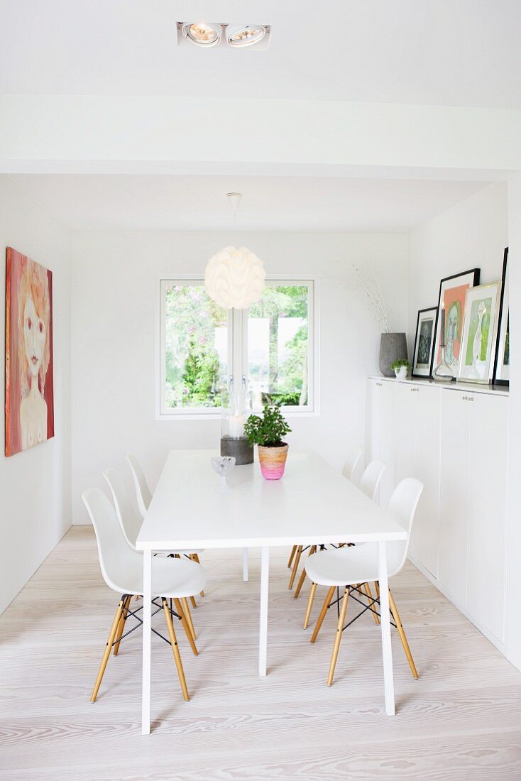 Moderner, weisser Küchentisch und Schalenstühle aus Bauhauszeit im Esszimmer