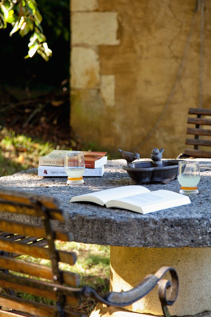 Buch auf Tisch mit Natursteinplatte auf der Terrasse