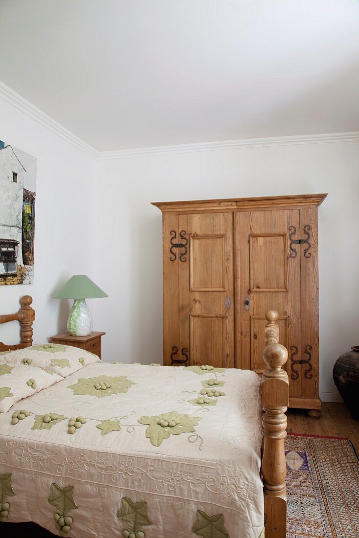 Bäuerliches Schlafzimmer - Doppelbett mit geschnitztem Holzgestell und Holzschrank mit Metallbeschlag