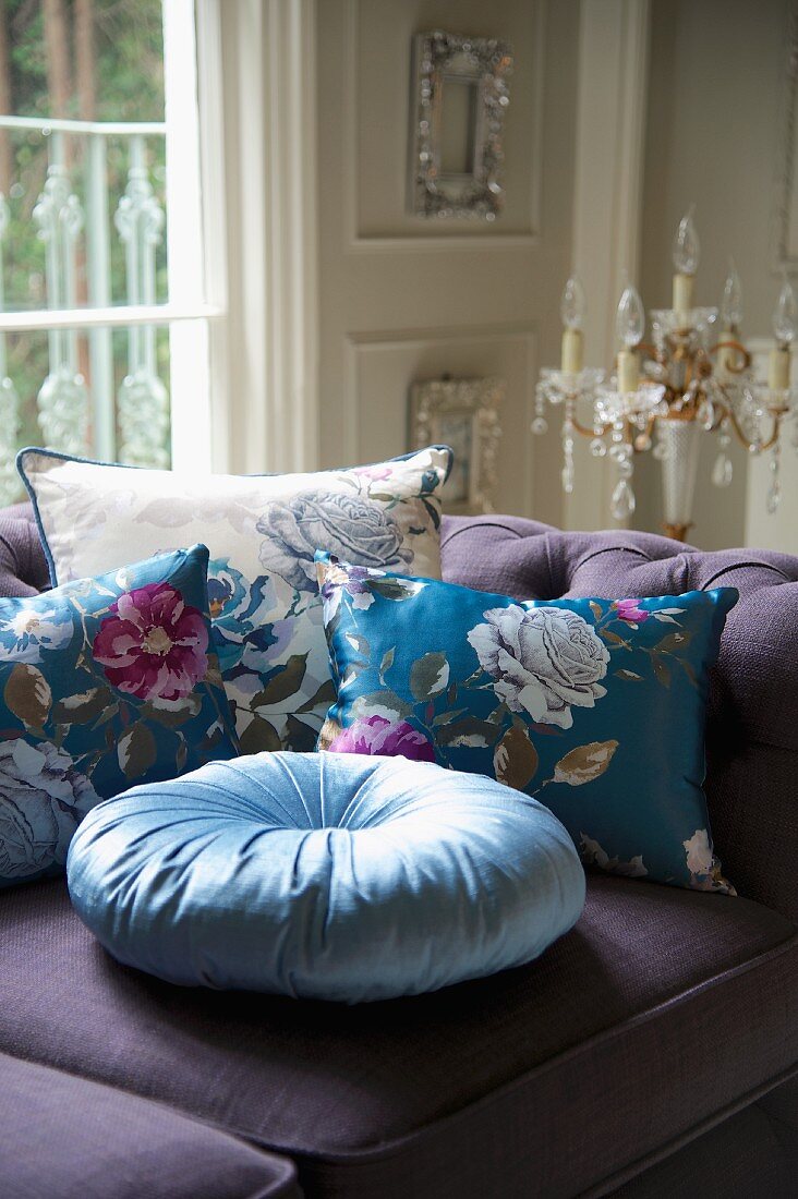 Floral scatter cushions on purple sofa