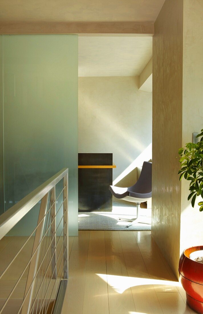 Flur mit modernem Metall Treppengeländer und Blick durch offenen Durchgang auf Drehstuhl