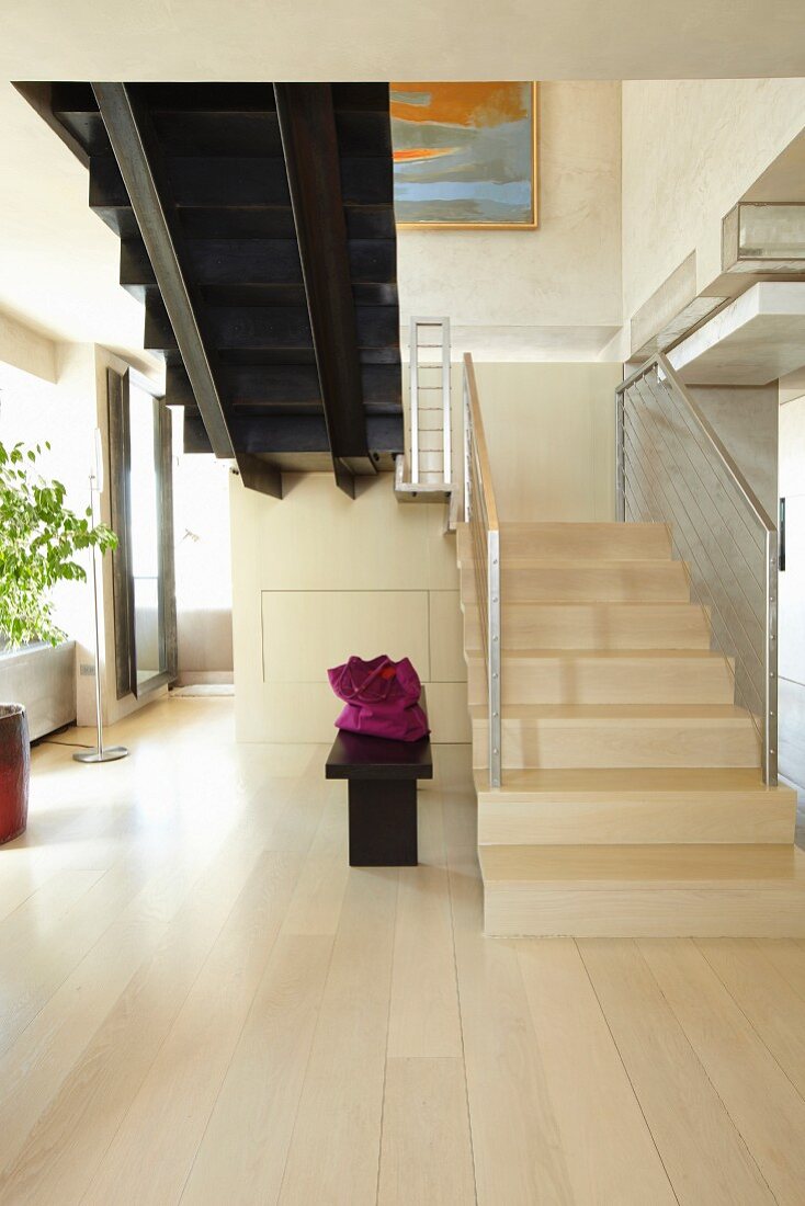Open modern living room with staircase made ​​of light wood
