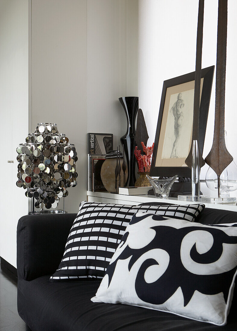 Black and white sofa pillows and various decorative elements on a sideboard