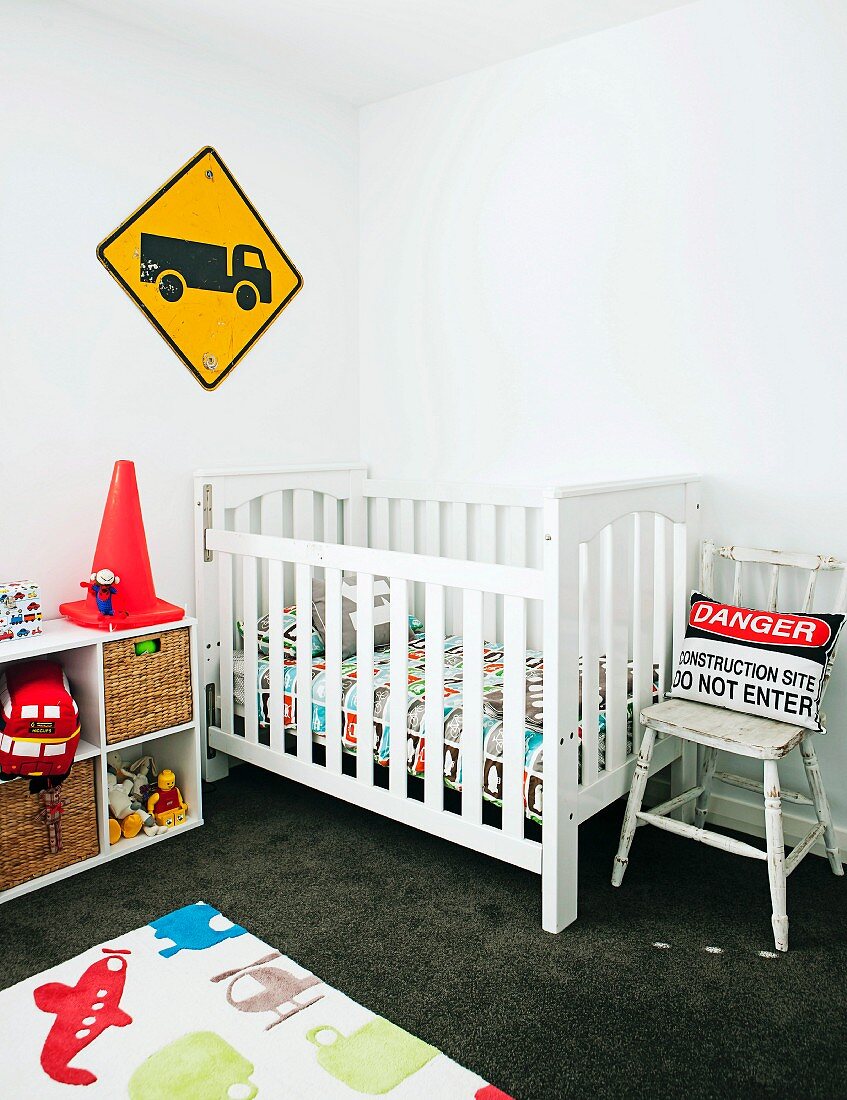 Kinderzimmer mit Gitterbett aus Holz, Spielzeugregal & Kinderteppich