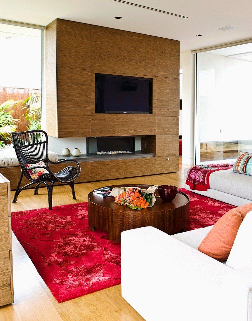 Floor-to-ceiling, walnut-veneer wall unit with integrated TV & gas fire in living room