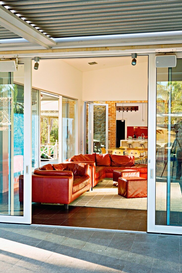 View from terrace through open sliding door of red leather sofa set in living room