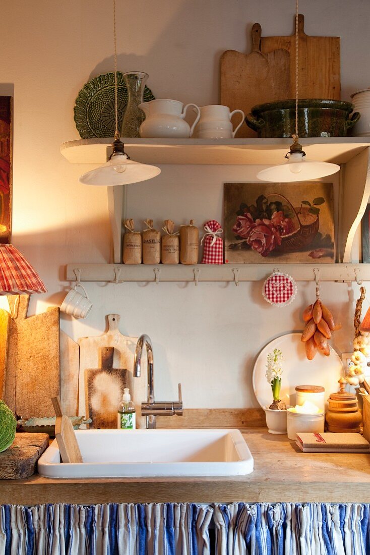 Holzarbeitsplatte mit Trogbecken und dekorierten Küchenutensilien in Landhausküche