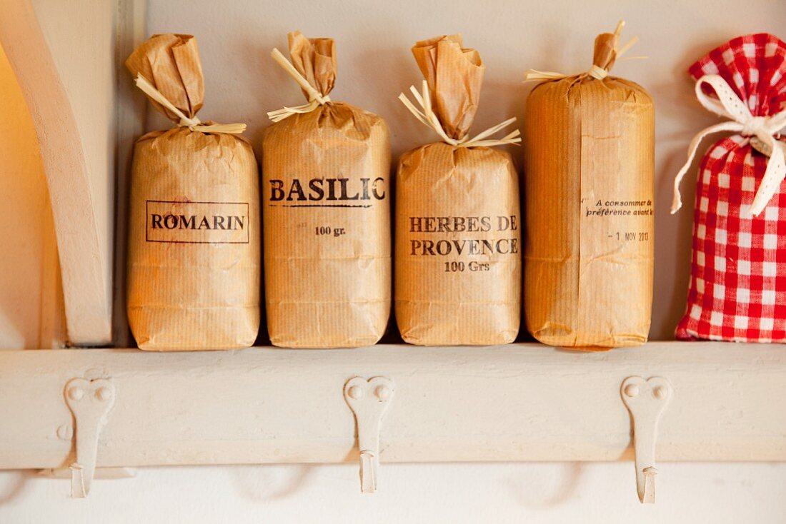 Labelled paper bags of herbs on kitchen shelf