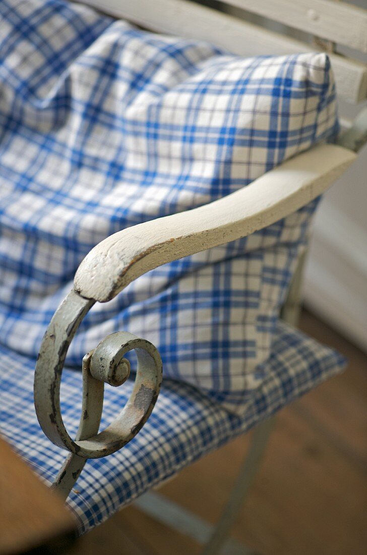 Blue and white checked textiles on old garden chair