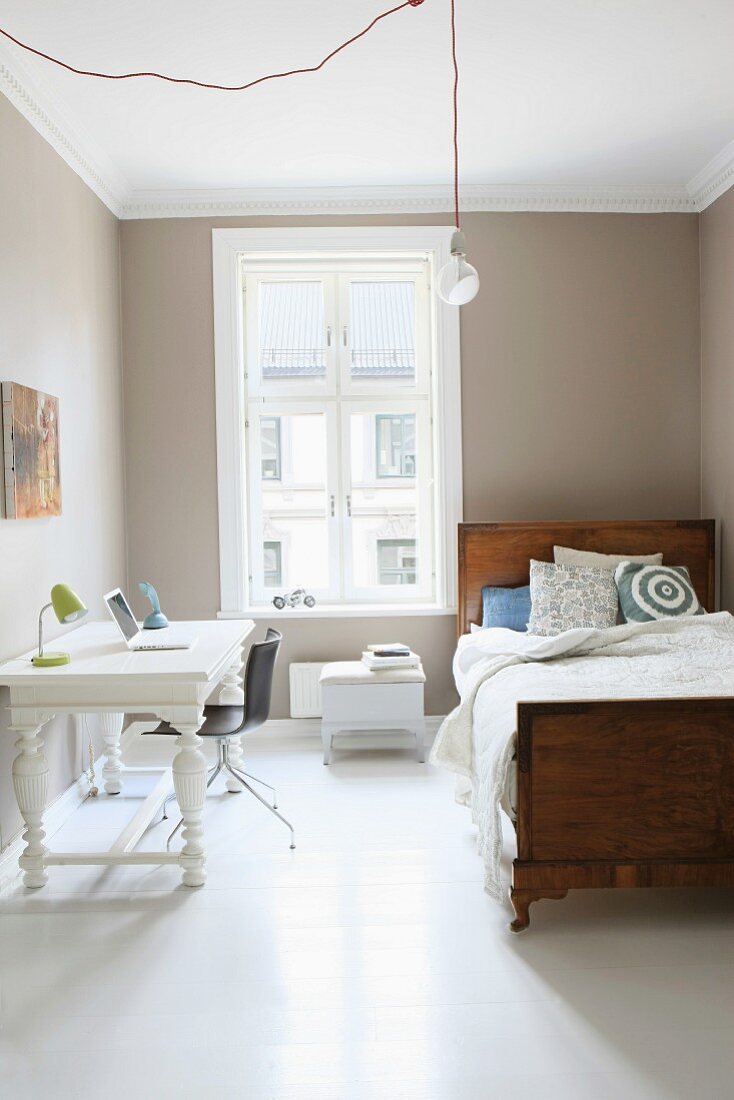 Einzelbett aus Holz und Arbeitstisch in renoviertem Zimmer mit traditionellem Flair