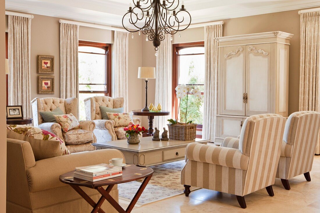 Sitzbereich im traditionellen Wohnraum mit Kombination eleganter, heller Landhausmöbel