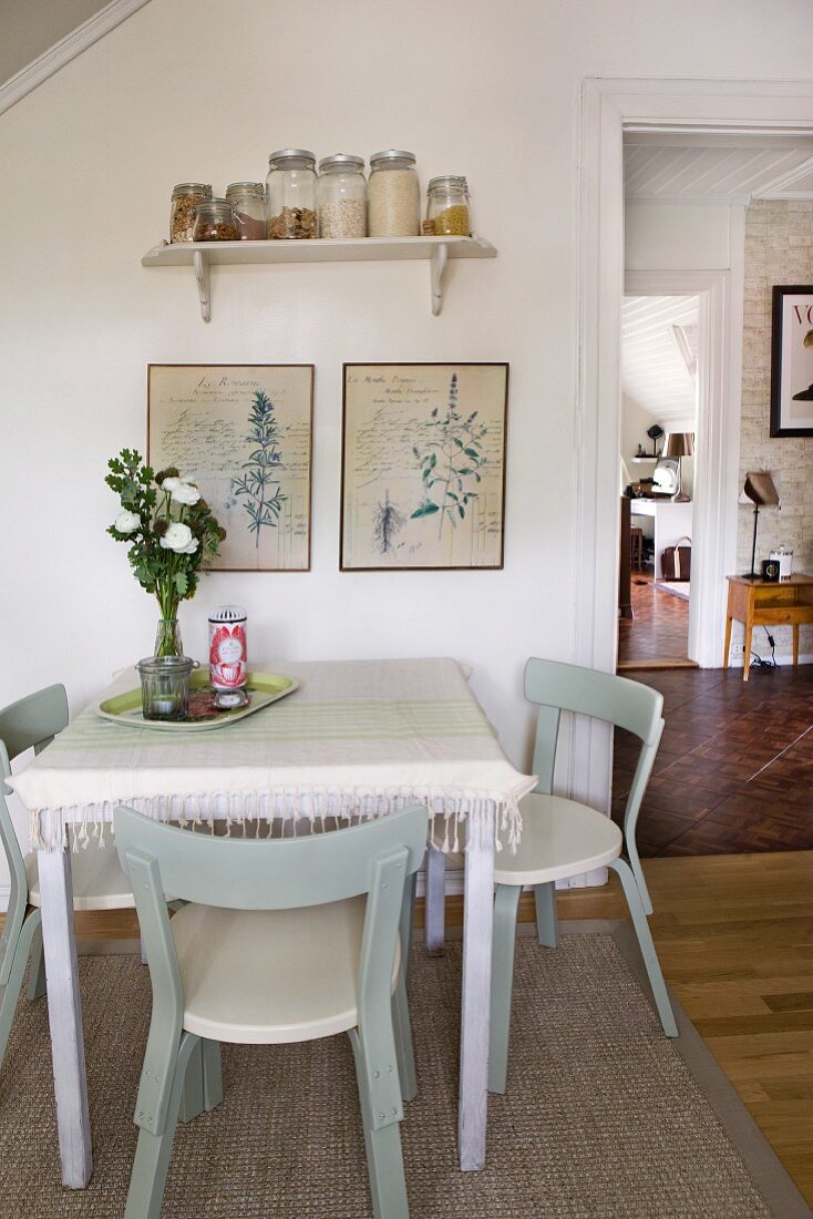 Retro dining area in kitchen-dining room with classic Scandinavian chairs and framed botanical drawings on wall