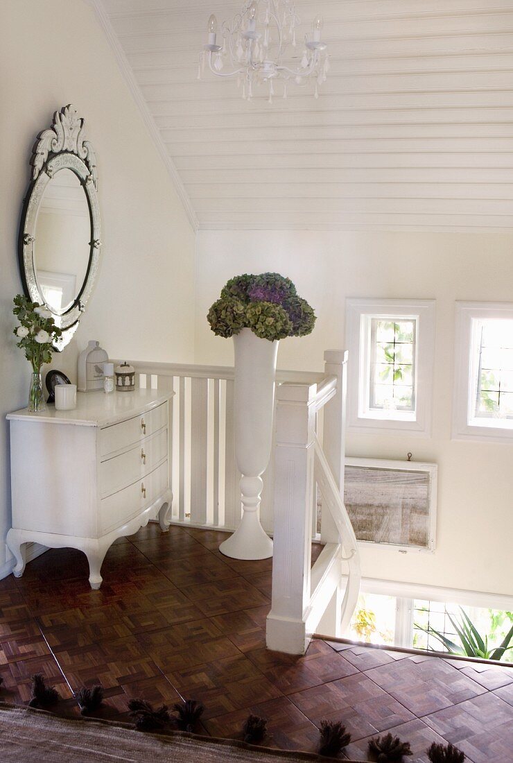 Weiß lackierte Holzkommode am obersten Treppenabsatz in skandinavischem Wohnhaus