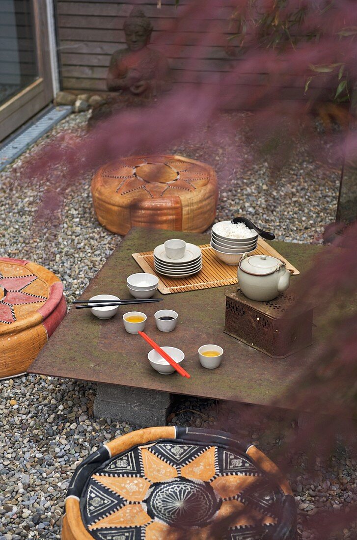 A romantic view through leafy twigs of a tea ceremony in an inner courtyard