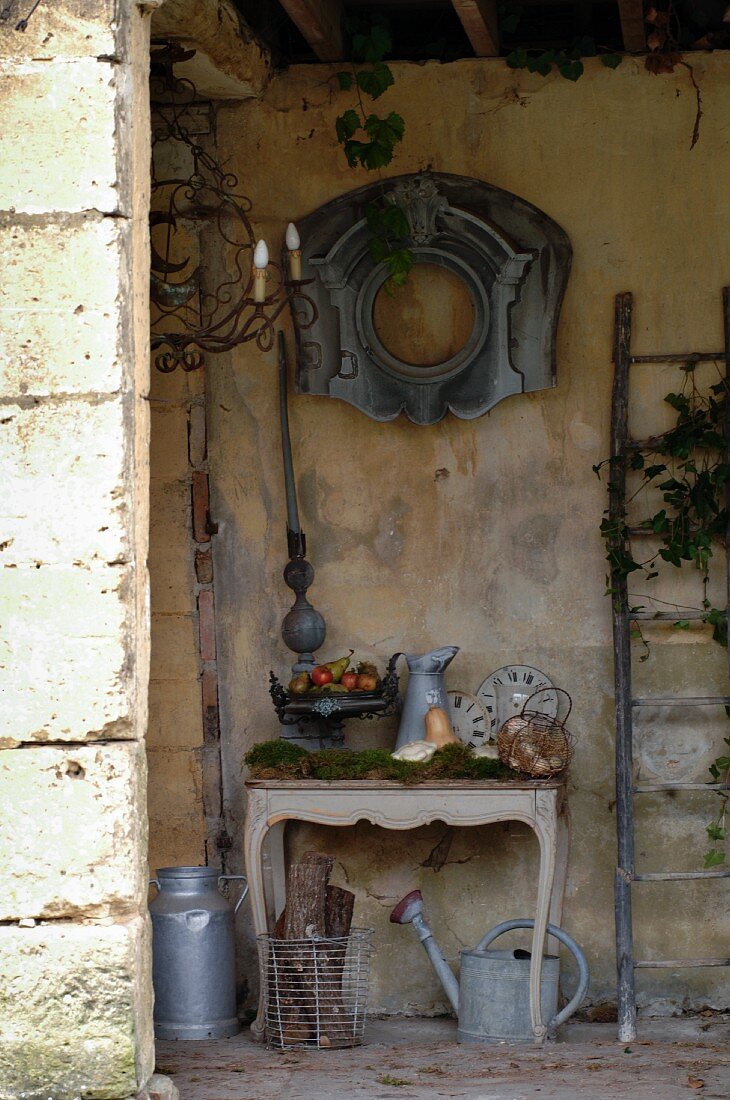 Arrangement of antique flea-market finds in roofed store area of old, French country house